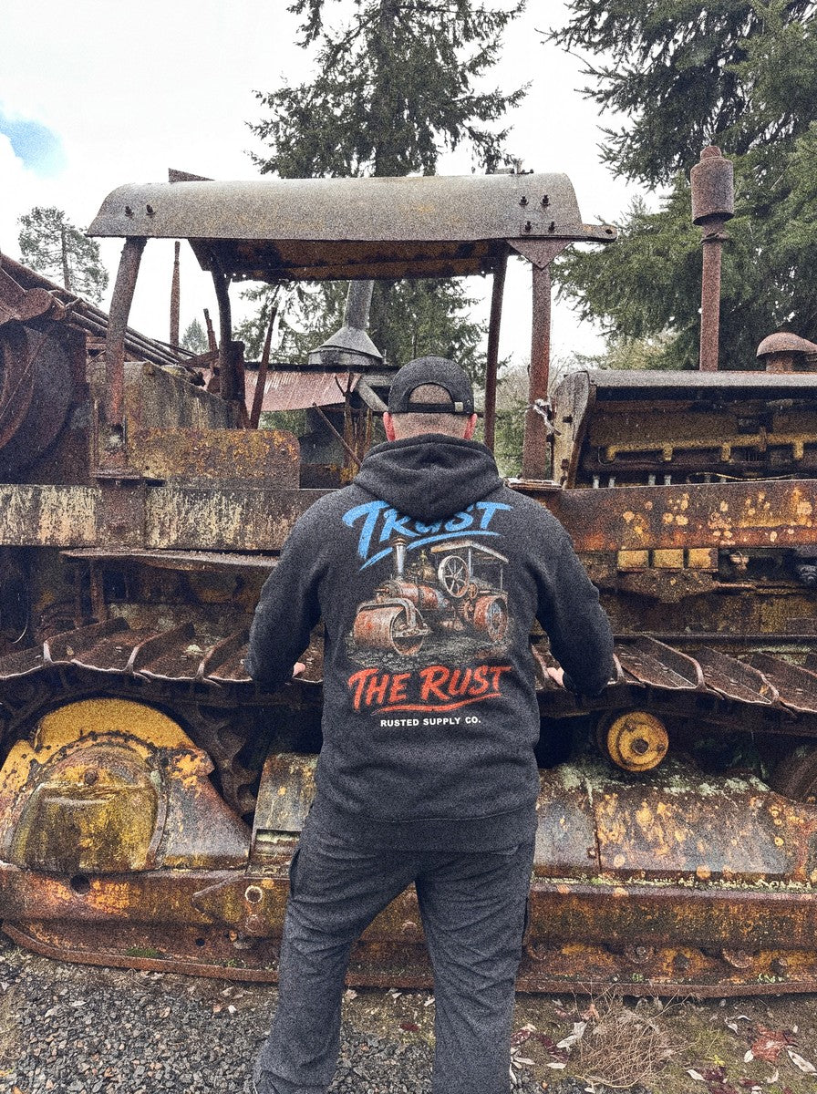 Operator in a TRUST THE RUST steam roller hoodie on a haul road