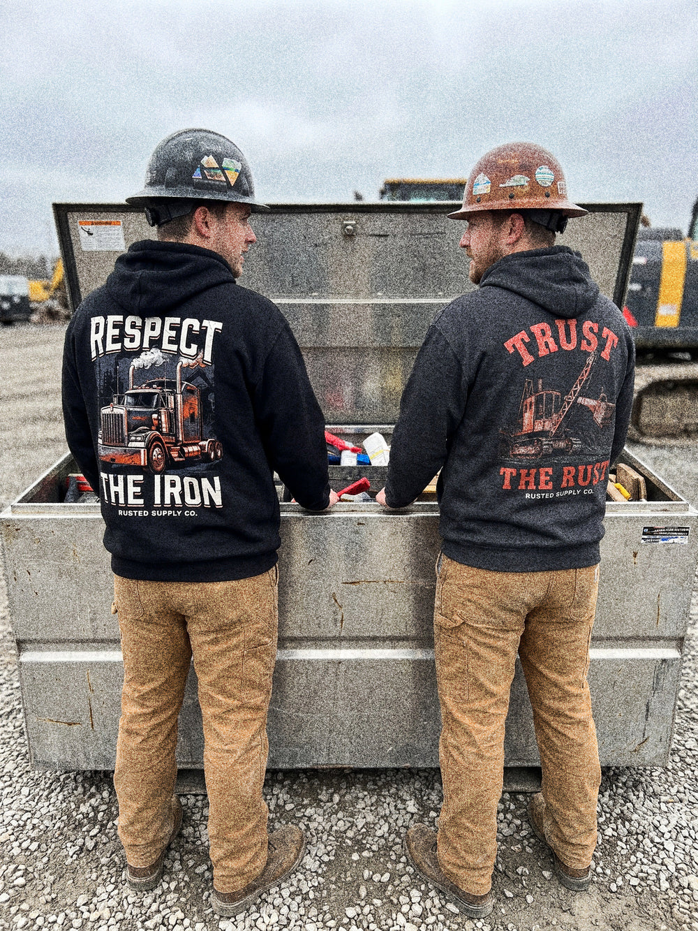 Two tradesmen at a gang box in RESPECT THE IRON and TRUST THE RUST hoodies