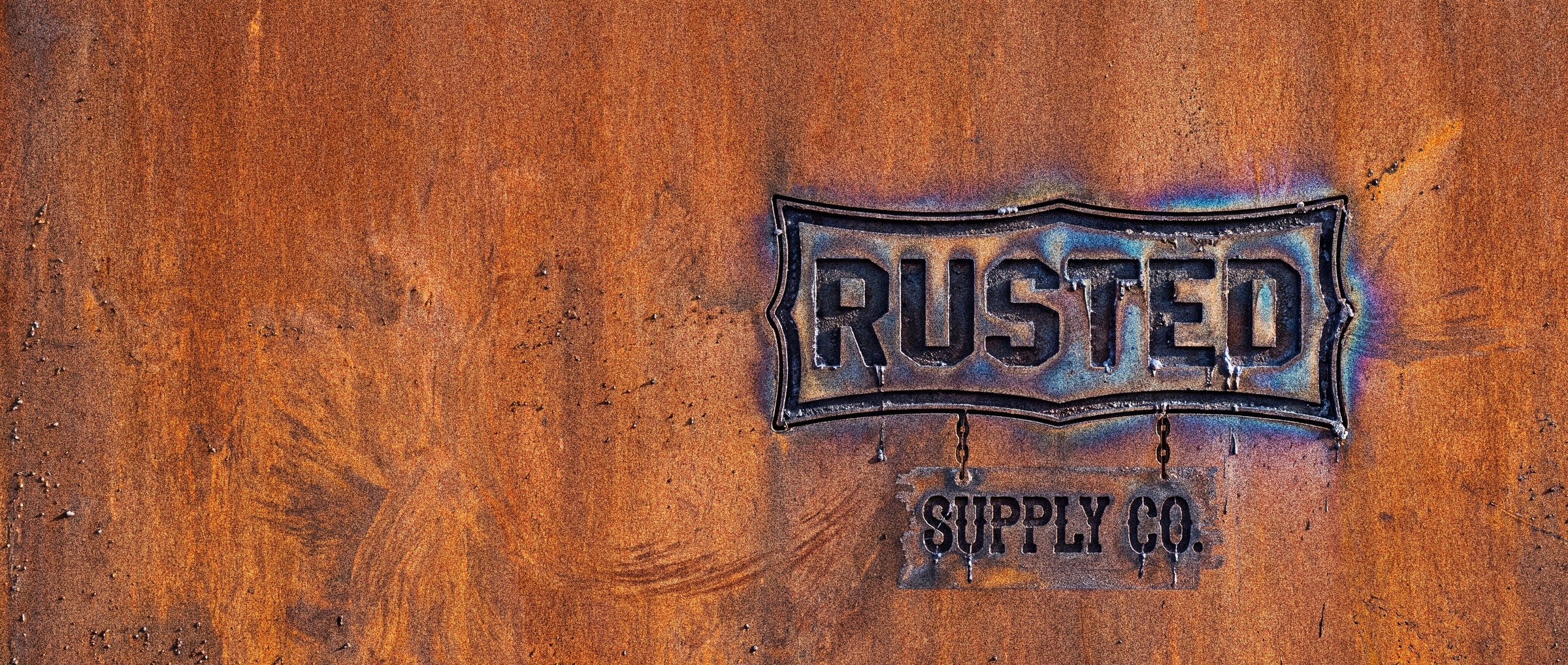 The RUSTED SUPPLY CO. mark torch-cut into a rusted steel plate