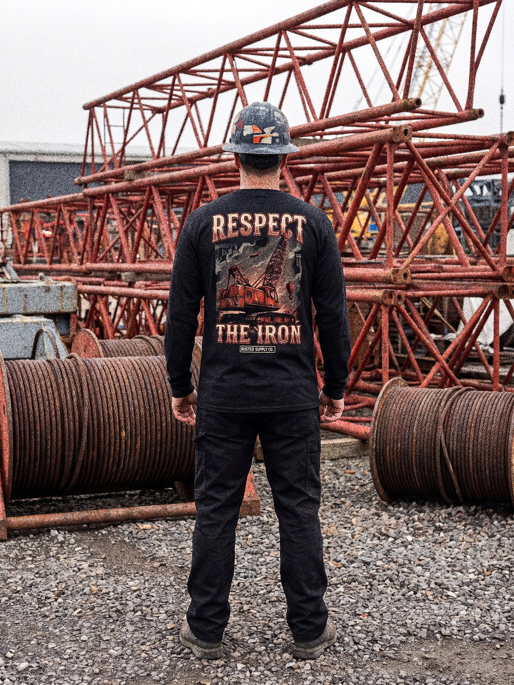 Tradesman in a RESPECT THE IRON crawler crane long sleeve in a crane yard