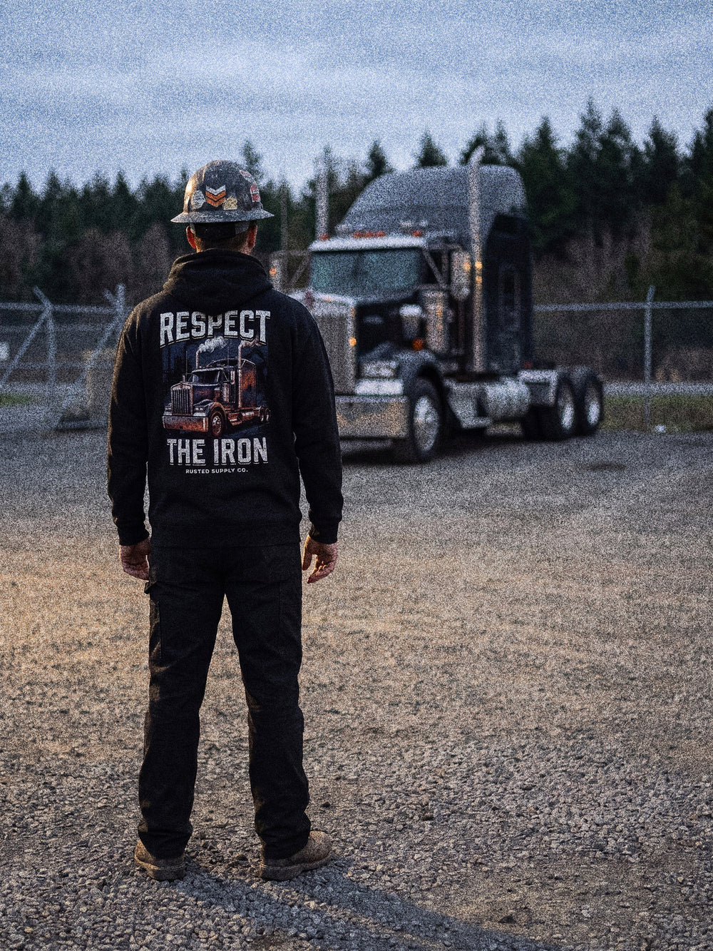 Tradesman in a RESPECT THE IRON conventional semi hoodie in a truck yard